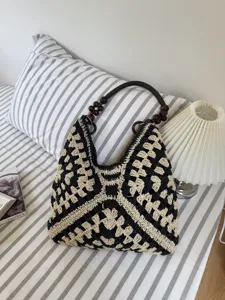 Black and beige woven shoulder bag hollow out straw beach tote bag with beaded handle.