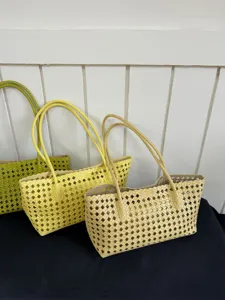 Woven tote bag detail showing hollow design, elegant stylish summer commuting handbag.