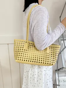Yellow woven tote bag detailed shot, stylish summer shoulder bag for women daily commute.