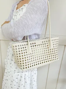 Detailed view of white woven cutout shoulder bag, stylish summer tote for women commute.