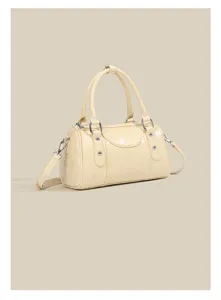 Close-up detail of the glossy light yellow bowling shoulder bag with metallic hardware.