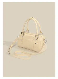 Yellow Boston shoulder bag, compact bowling handbag with handle and strap, detailed close-up.