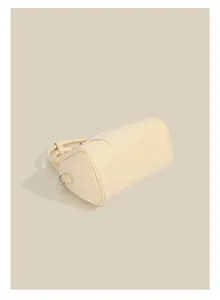 Detailed view of cream minimalist Boston shoulder bag, stylish commuter bowling handbag.