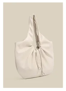 Primo piano dettagliato di un'elegante borsa a spalla plissettata beige in morbida finta pelle.