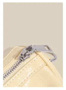 Detail view of cream beige boston shoulder bag featuring metal zipper and fine stitching.