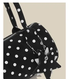 Black and white polka dot handbag detail with star charm, stylish shoulder bag for women.