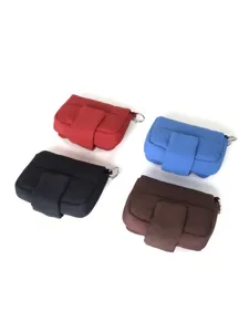 Primo piano della piccola custodia trapuntata con patta e anello metallico in vari colori.