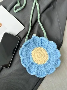 Handmade crochet flower cross-body bag featuring blue petals and green strap detail.