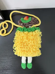 Handmade crochet cartoon girl phone bag, cute knitted crossbody bag with yellow strap.
