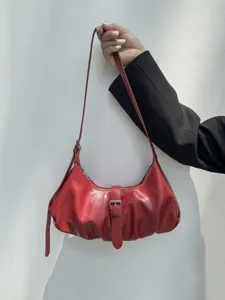 Detailed view of a chic red PU leather dumpling shoulder bag featuring stylish pleats and buckle.