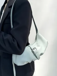 Detailed view of light green dumpling shoulder bag with chic metal buckle and leather.