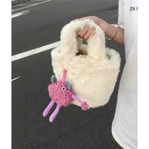 Fluffy faux fur bucket bag with cute pink monster plush pendant, stylish winter handbag.