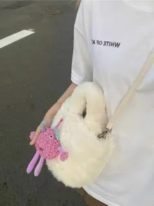 White plush bucket bag for women with cute pink monster pendant, casual furry crossbody bag.
