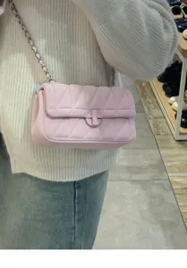 Detalle de bolso cruzado acolchado rosa, cadena elegante y cierre chic para uso diario.