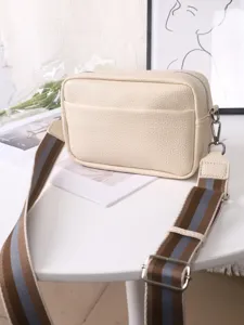 Detailed view of women's PU leather crossbody camera bag with wide striped strap in beige.