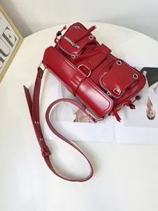Stylish red motorcycle shoulder bag with multi-pocket and metal grommet details for women.