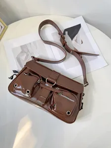 Brown patent leather motorcycle shoulder bag, glossy finish with front pockets and zippers.