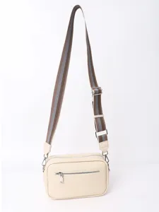 Detail view of beige PU leather crossbody bag with brown striped strap and front zipper.