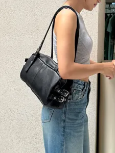 Close-up detail of the black leather Boston shoulder bag showcasing its stylish side buckle design.