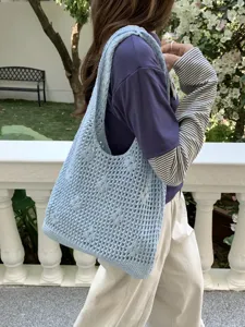 Detailed view of the light blue hollow knitted shoulder bag, casual crochet tote for daily use.