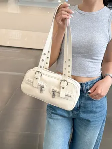 Detail shot of a stylish white bowling shoulder bag with dual straps, zippers and metal eyelets.