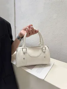 White leather Boston handbag detail shot, elegant commuting style, premium shoulder bag accessory.