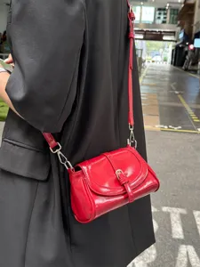 Red patent leather crossbody small square bag with chic metal buckle and shoulder strap.