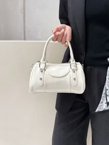 Detail shot of white leather Boston handbag with silver hardware and double top handles.