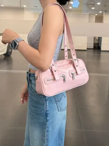 Pink retro shoulder bag featuring dual front zipper pockets and chic buckle straps.