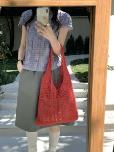 Red knit hollow out tote bag detail view, casual summer shoulder bag with net design texture.