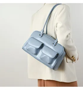 Detail view of light blue retro shoulder bag with dual front pockets for women daily commute.