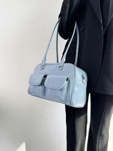 Light blue retro shoulder handbag with dual front pockets and metallic zippers for daily commute.