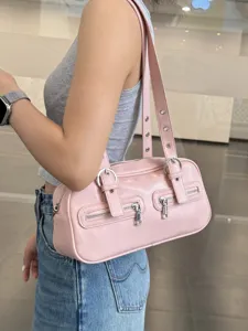 Detail shot of a pink retro bowling shoulder bag featuring front zippers and metal eyelets.