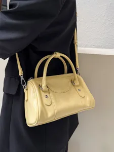 Detail shot of a stylish light yellow patent leather boston bag, chic shoulder crossbody.