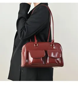Retro patent leather shoulder bag detail view, wine red color featuring dual front pockets.