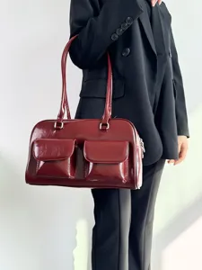 Retro college style patent leather shoulder bag with double front pockets for daily commuting.