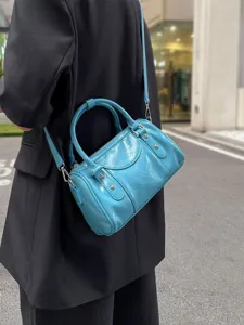 Stylish blue bowling shoulder bag worn on shoulder, showing fashionable daily commuting style detail.