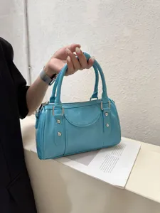 Light blue bowling bag detail, glossy leather finish, metal hardware, chic top handle design.