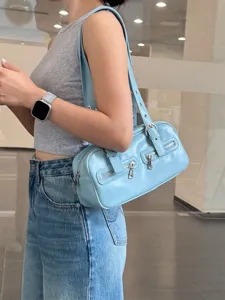 Light blue leather bowling shoulder bag detail showcasing dual front zippers and metal hardware.