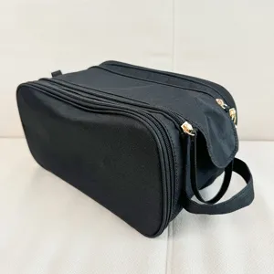 Black multi-layer travel toiletry bag detail showing durable fabric and double zipper design.