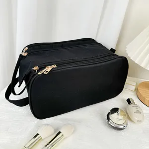 Detailed view of black multi-layer cosmetic bag, showing durable canvas and gold zippers.