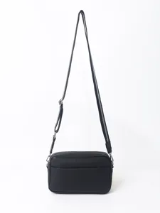 Black PU leather crossbody bag detail showcasing texture and adjustable strap hardware.