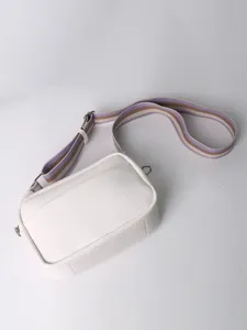 Minimalist white PU leather crossbody bag detail showing texture and striped strap.