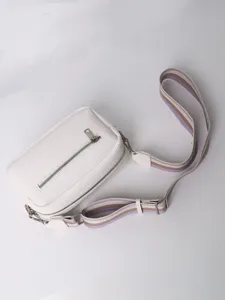 White PU leather crossbody bag detail, textured surface and striped strap design.