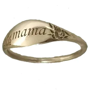 Primer plano detallado del anillo de metal grabado mama con textura floral delicada.