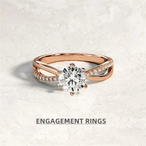 Primo piano dell'anello di fidanzamento in oro rosa con diamante centrale e fascia incrociata.
