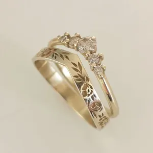 Primo piano dell'elegante set di anelli impilabili con fascia floreale e zircone scintillante.
