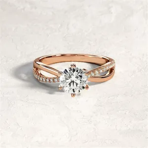 Dettaglio primo piano dell'anello incrociato in oro rosa con pietra centrale e pavé.