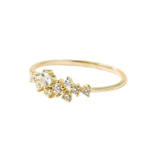 Nahaufnahme eines filigranen Goldrings mit einer asymmetrischen Gruppe funkelnder Kristalle.