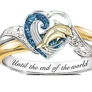 Exquisito anillo de corazón de delfín bicolor con detalle de ola brillante y grabado.